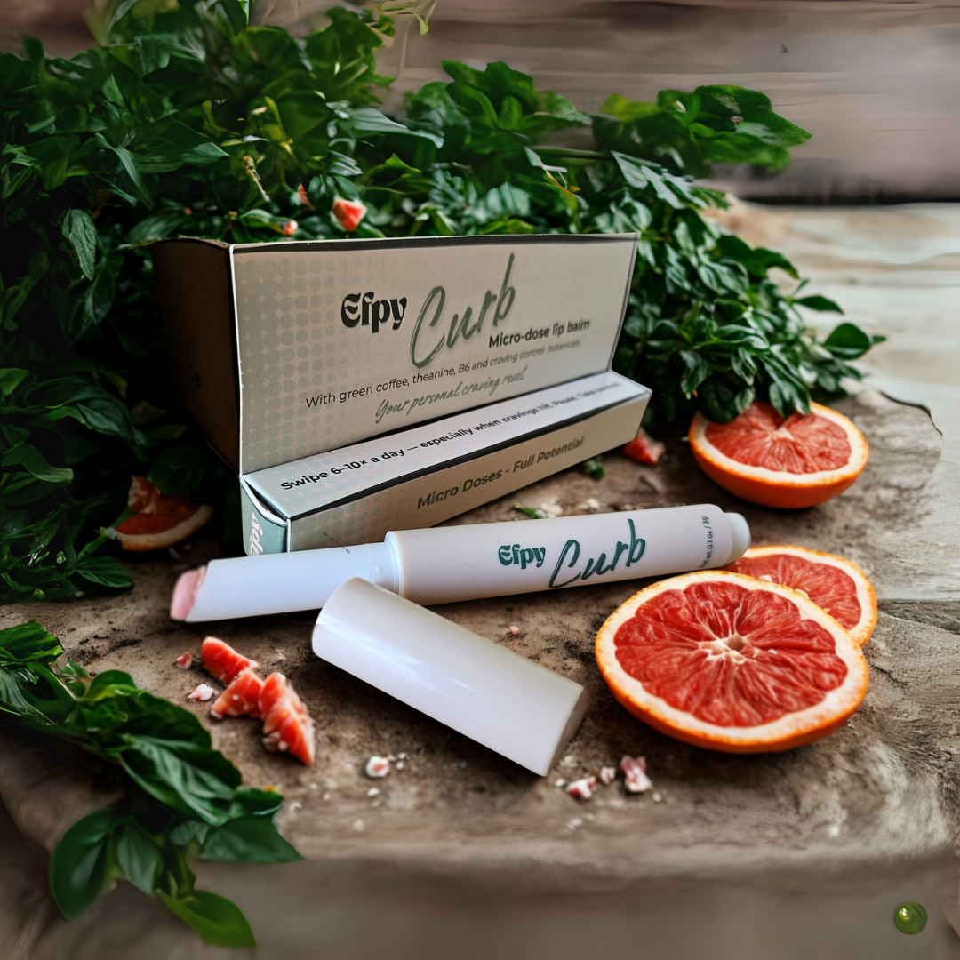 Eipy Curb lip balm with packaging on a wooden surface with grapefruits and mint leaves.