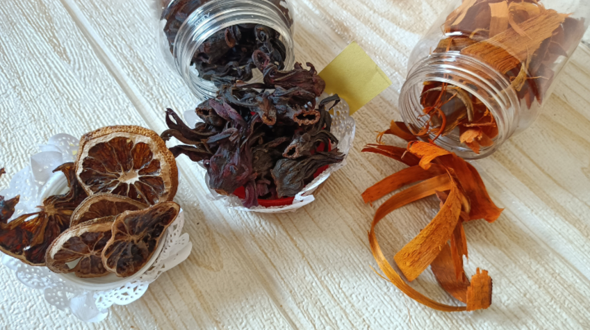 Spices and herbs in small containers on a wooden surface