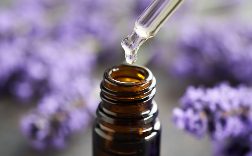 Brown glass bottle with dropper over lavender flowers